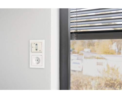 Wandszene mit Lichtschalter, Steckdose und Fenster mit Jalousie