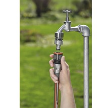 Gartenschlauch wird an einen Wasserhahn angeschlossen