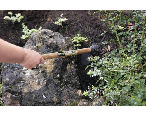 Gartenhacke mit Holzgriff im Einsatz in einem Gartenbeet.