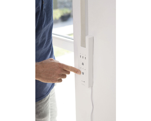 Person bedient eine Rollladensteuerung an der Wand