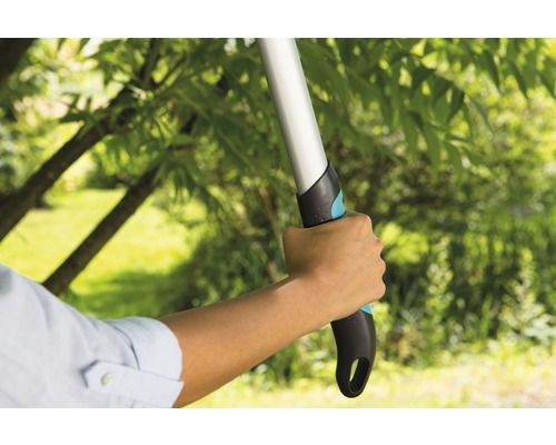 Person hält eine Baumpflegesäge im Garten.