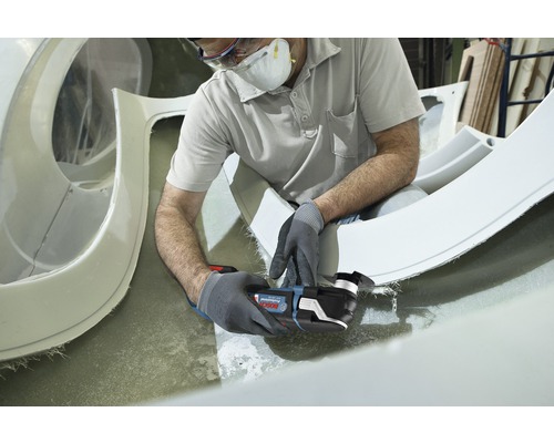 Handwerker bei der Arbeit mit einem Multifunktionswerkzeug zum Schneiden von Bauteilen