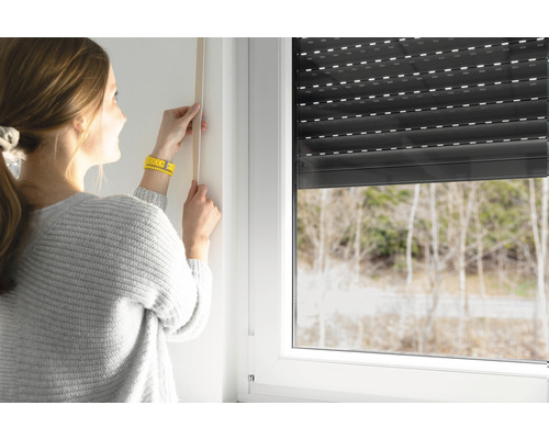 Frau misst Fenster für Rollladenmontage