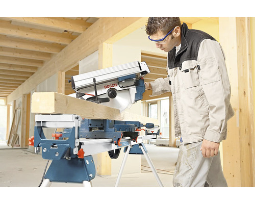 Gehrungssäge beim Schneiden eines Holzstücks mit einer Person, die eine Schutzbrille trägt