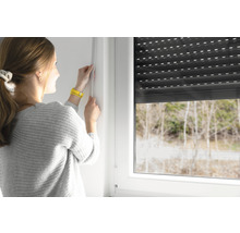 Frau misst Fenster für Rollladenmontage