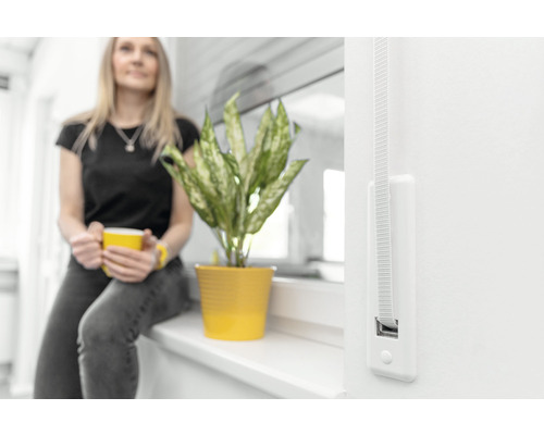 Detailaufnahme eines weißen Rollos mit Bedienband in einem hellen Raum