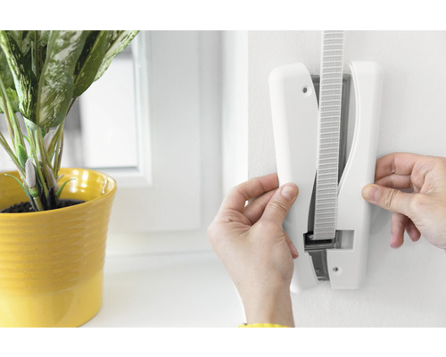 Montage einer Jalousiehalterung an einer Wand mit Pflanze in gelbem Topf