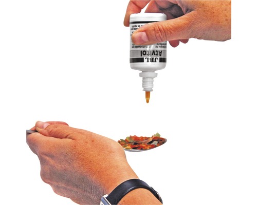 JBL Atvitol wird auf einen Löffel Fischfutter geträufelt.