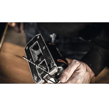 Nahaufnahme einer Stichsäge mit Sägeblatt in einer Hand