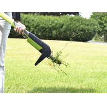 Person verwendet einen Unkrautstecher im Garten