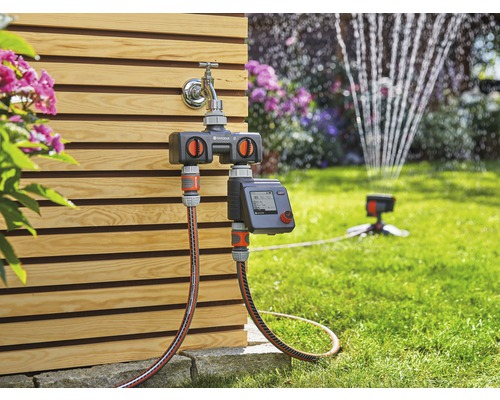 Gardena Wasserverteiler Automatic an Wasserhahn mit Gartenschlauch und Rasensprenger im Garten