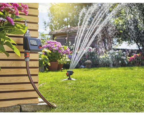 Gartenbewässerungssystem mit Steuergerät, Schlauch und Rasensprenger im Betrieb