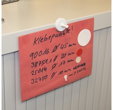 Ein rotes Blatt Papier mit Informationen zu Klebepunkten, befestigt mit einem weißen Magneten.