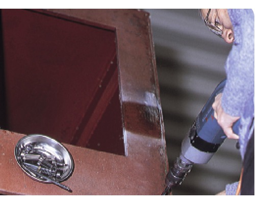 Handwerker arbeitet mit Bohrmaschine an Stahlkonstruktion