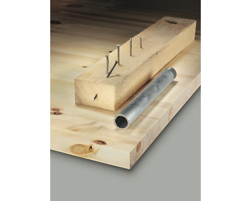 Holzbrett mit Nägeln in einem Holzstück und einem Rohr