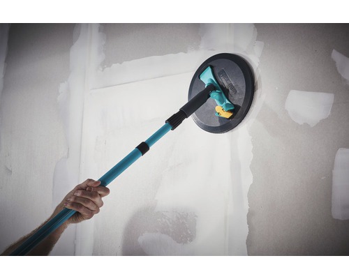 Eine Person verwendet einen Deckenschleifer mit Teleskopstiel an einer Wand.