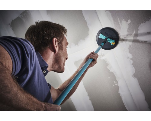 Mann schleift Wand mit Schleifgiraffe für Renovierungsarbeiten