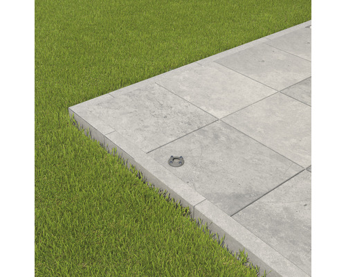 Graue Terrassenplatten mit Rasen und einer Bodenleuchte