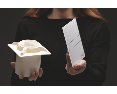 Person hält Belüftungsventil und Abdeckplatte in der Hand