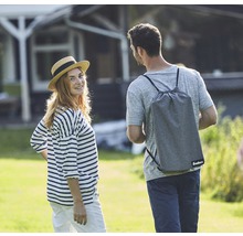 Eine Frau und ein Mann im Garten, der Mann trägt eine Tragetasche der Marke Enders