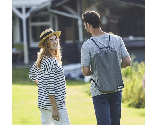 Eine Frau und ein Mann im Garten, der Mann trägt eine Tragetasche der Marke Enders