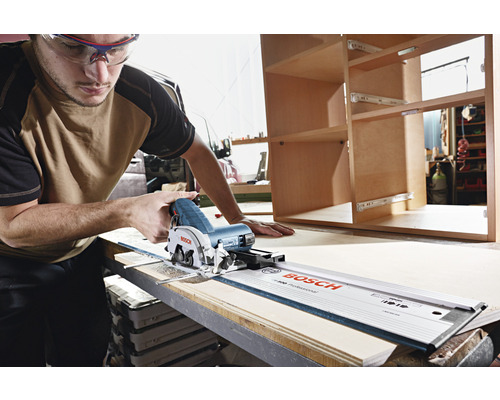 Mann schneidet Holz mit einer Tauchsäge und Führungsschiene von Bosch