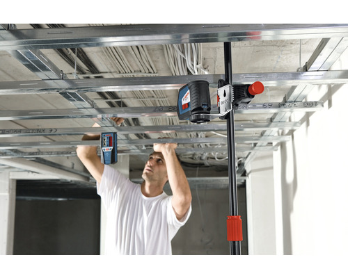 Mann montiert Deckenkonstruktion mit Laser Nivelliergerät