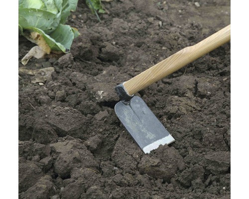 Hacke mit Holzstiel im Gartenboden