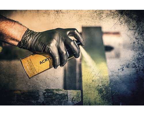 Eine Hand mit Schutzhandschuh benutzt eine Acryl Sprühdose.