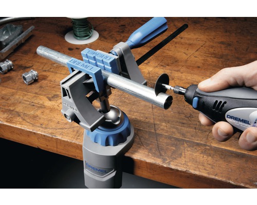 Dremel Logo. Werkbank mit Dremel Multi-Spannstock und Dremel Multifunktionswerkzeug beim Durchtrennen eines Rohres.