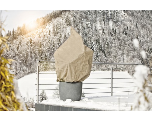 Pflanztopf mit Winterschutzhaube auf einer Terrasse im Winter