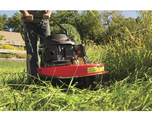 Mann bedient eine Motorsense zum Schneiden von hohem Gras