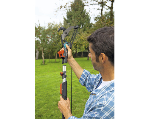 Ein Mann montiert eine Gardena Astschere an einer Teleskopstange im Garten.