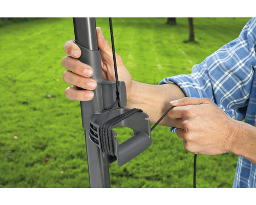 Person bedient Seilzugmechanismus eines Sonnenschirms