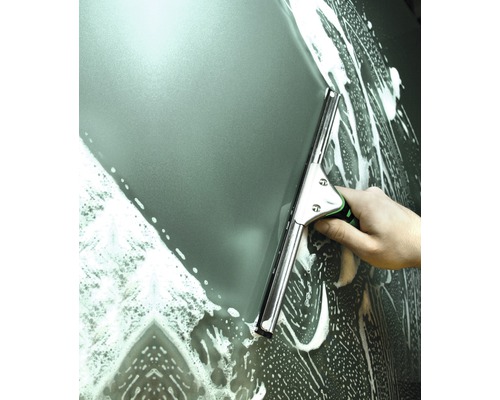 Hand wischt mit einem Fensterabzieher eine schaumige Glasoberfläche