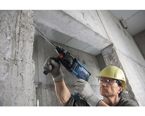 Mann bohrt mit einem Bosch Bohrhammer in eine Betonwand
