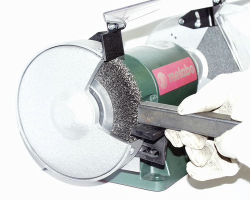 Metabo Tischschleifer mit Drahtbürste beim Bearbeiten eines Metallstücks