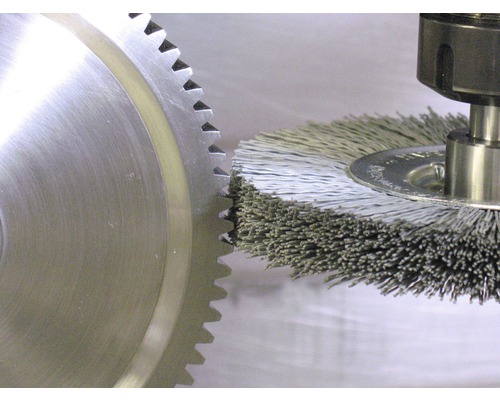 Drahtbürste im Einsatz an einem Zahnrad