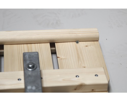 Detailansicht einer Holzkonstruktion mit Schrauben und Metallbeschlag