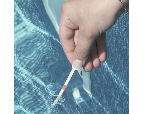 Eine Person testet mit einem Teststreifen die Wasserqualität eines Pools.