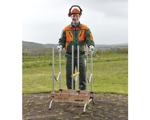 Ein Mann mit Schutzkleidung steht hinter einer Holzablage von Wolfcraft, die im Freien aufgestellt ist.