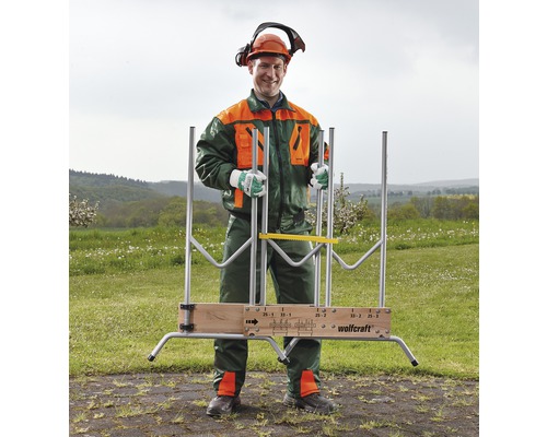 Mann mit Schutzkleidung und Wolfcraft Holzsägebock im Freien