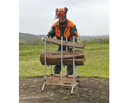 Mann befüllt eine Holzstapelhilfe von Wolfcraft mit Holzstücken.