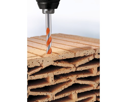 Bohrmaschine bohrt Loch in Ziegelstein