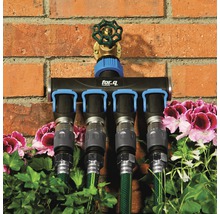 for.q Verteiler mit vier Anschlüssen und angeschlossenen Gartenschläuchen vor einer Ziegelwand