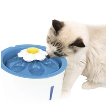 Katze trinkt aus einem blauen und weißen Trinkbrunnen
