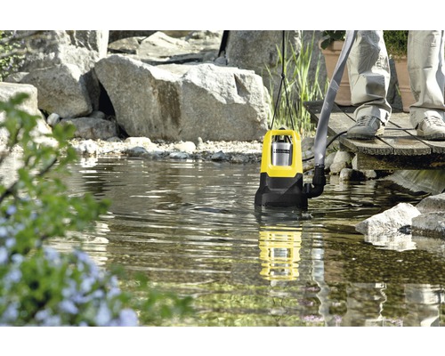 Teichpumpe im Gartenteich mit Steinen und Pflanzen
