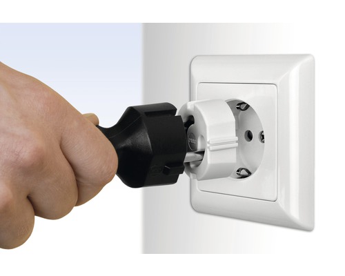 Eine Hand steckt einen Schutzkontaktstecker in eine Steckdose mit Kindersicherung.
