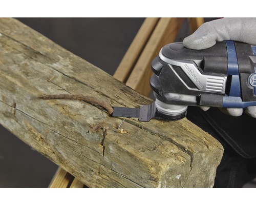 Multifunktionswerkzeug im Einsatz zum Entfernen eines Nagels aus einem Holzbalken