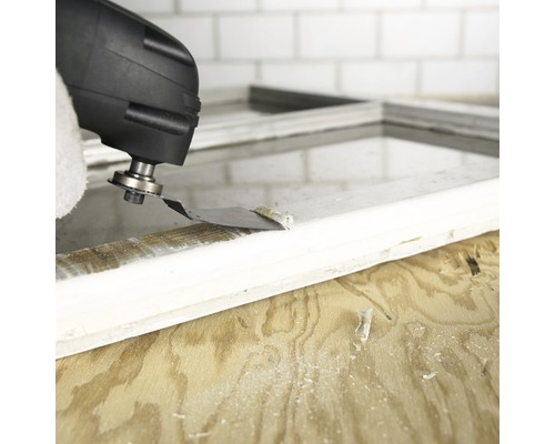 Oszillierendes Elektrowerkzeug beim Entfernen von Farbe von einem Fensterrahmen